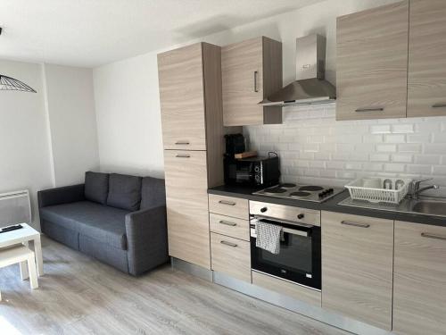利布尔讷Appartement neuf en centre ville de Libourne的带沙发和炉灶的厨房 顶部烤箱