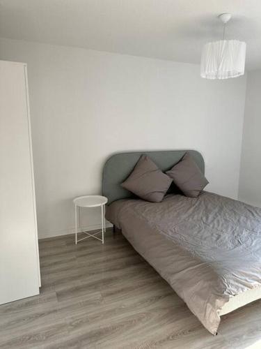 利布尔讷Appartement neuf en centre ville de Libourne的一间卧室配有一张床和一张小桌子