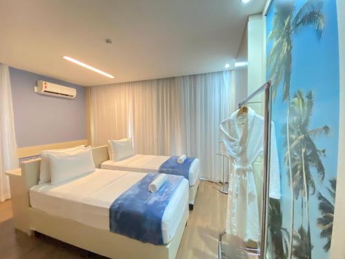 累西腓FLAT Praia Boa Viagem的酒店客房设有两张床和窗户。