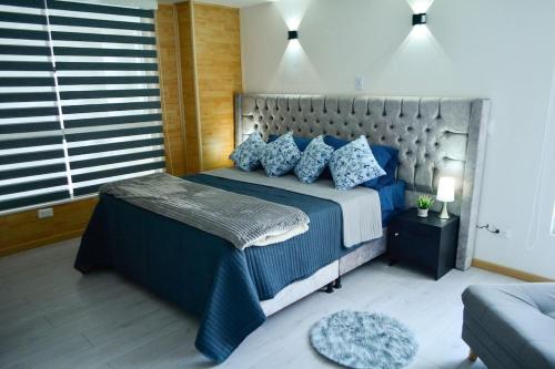马尼萨莱斯Apartamentos cómodos en Milan zona G的一间卧室配有一张带蓝色枕头的大床
