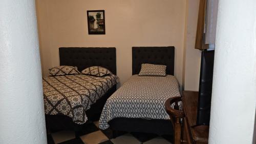 埃雷迪亚巴利亚多利德酒店的小房间设有两张床和一张桌子