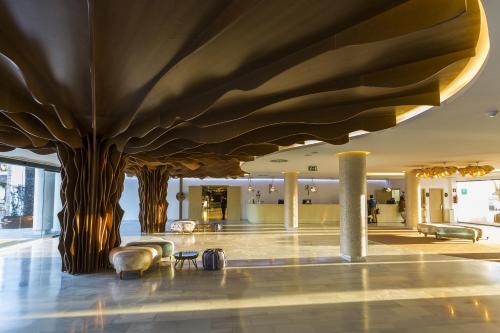普拉亚登博萨Grand Palladium White Island Resort & Spa - All Inclusive的大堂的树从天花板上长出来