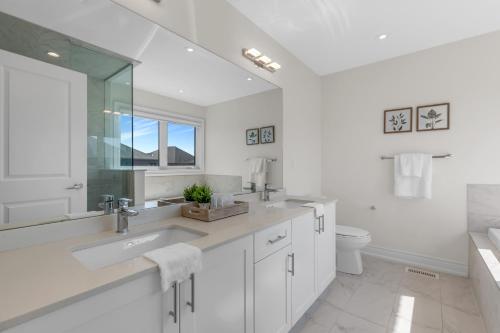 布兰普顿Luxury 6 Bedroom - 4 Bathroom Detached Retreat Brampton / Mississauga Border的白色的浴室设有水槽和卫生间。