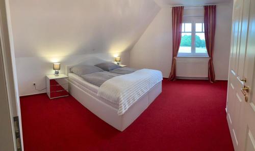 阿希姆Ferienwohnung für 4 Personen in bester Lage ca. 15 km von Bremen City的卧室配有白色床和红地毯