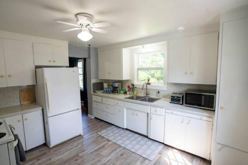 弗雷德里克顿Family Place that Feels like Home的厨房配有白色橱柜和白色冰箱。
