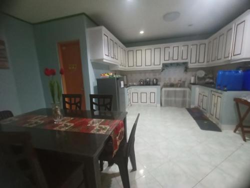 独鲁万La Residencia Tacloban的厨房配有白色橱柜和桌椅