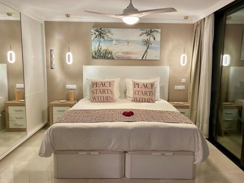 帕塔拉瓦卡Doñana 1027的卧室配有白色的床,上面有红玫瑰