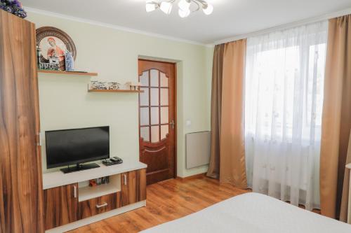 亚列姆切Фенікс的一间卧室配有电视、一张床和一个窗户。