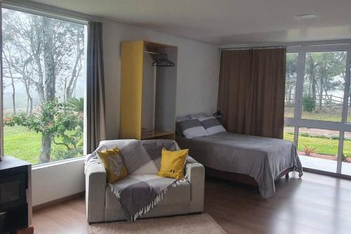 新彼得罗波利斯Alto do morro的一间卧室配有一张床、一张沙发和一把椅子