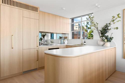 悉尼Harbour Bliss - Exquisite Design, Breathtaking Views的厨房配有木制橱柜和白色台面