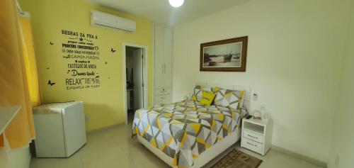 萨夸雷马Pousada da Drica的一间卧室配有一张黄色和白色的被子。