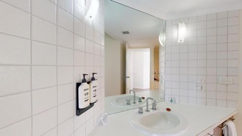 洛恩坎伯兰洛恩度假村的白色瓷砖浴室设有水槽和镜子