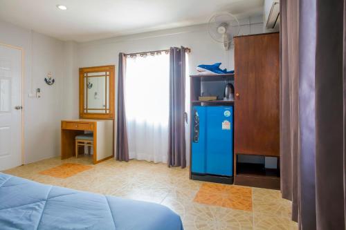 功孟海滩空芒日落之家酒店的客房配有蓝色冰箱和书桌。