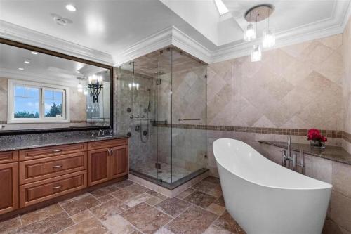 温哥华Spacious Cozy House in Vancouver West的大型浴室设有浴缸和淋浴。