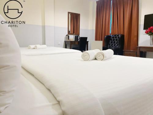 新山Chariton Hotel Skudai Kiri的两张位于酒店客房的床,配有毛巾