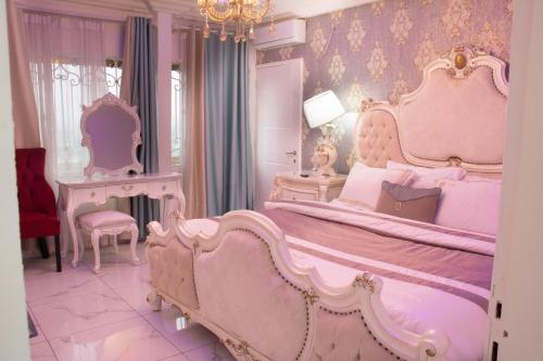 BueaRovie Estates的粉红色的卧室设有一张大床和吊灯