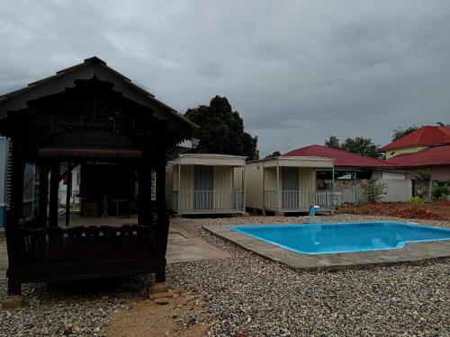 双溪大年Homestay Pinang Tunggal Cabin的庭院中带凉亭的小游泳池