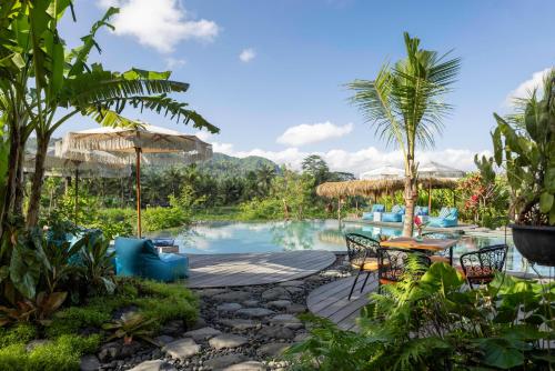 SilebengNatya River Sidemen的一个带游泳池和桌椅的度假酒店