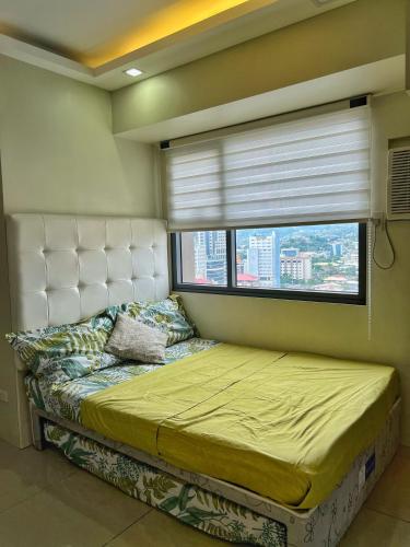 宿务Horizons 101 Condo in Cebu City的一间卧室设有一张大床和窗户