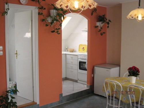 巴拉顿菲赖德弗里的公寓酒店的厨房设有橙色墙壁、桌子和用餐室。