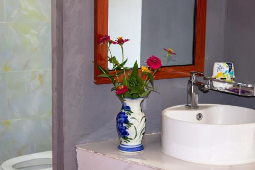 贡布Sabay Farm的蓝色和白色的花瓶,水槽上放着鲜花