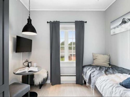 GarderComfy studio near Airport的一间卧室配有一张床、一张桌子和一个窗户。