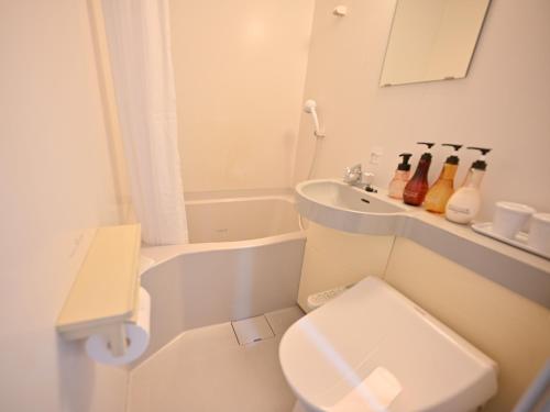 石垣岛ホテルアビアンパナ石垣島的白色的浴室设有卫生间和水槽。