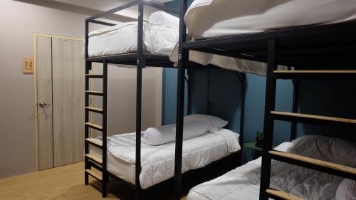 春蓬A lazy person hostel的客房设有2张双层床和白色枕头。
