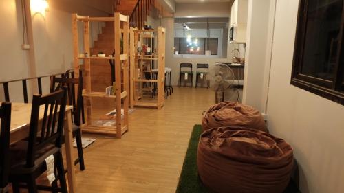 春蓬A lazy person hostel的客厅铺有木地板,走廊配有椅子