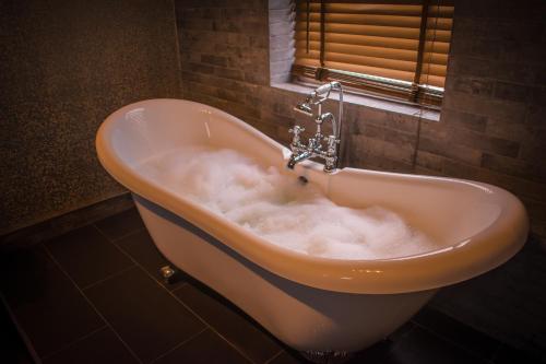 罗瑟勒姆The George Wright Boutique Hotel, Bar & Restaurant的浴室内设有泡沫浴缸。