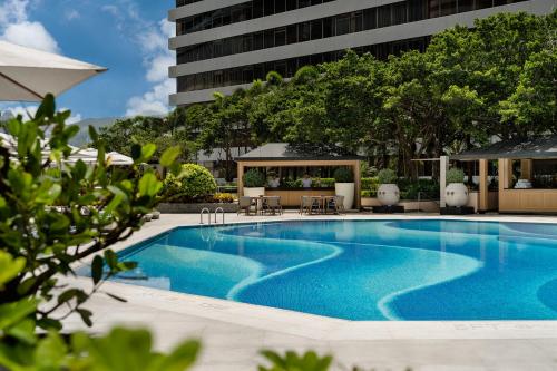 香港香港丽晶酒店的一座带椅子的游泳池以及一座建筑