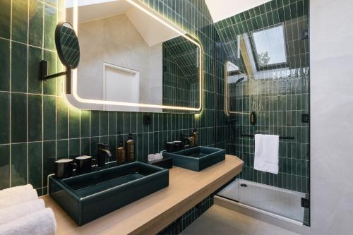 维也纳Bio-Hotel Schani Wienblick的浴室设有两个绿色水槽和镜子