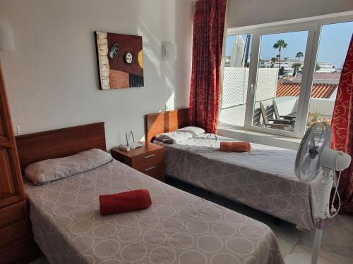 阿德耶Island Village的酒店客房设有两张床和窗户。