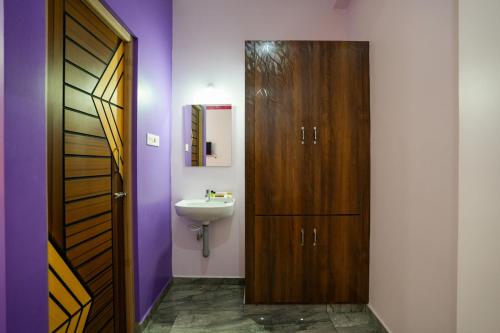 蓬蒂切里Selva Inn的一间带水槽和木门的浴室