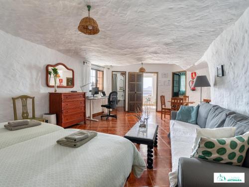 阿尔特纳拉Living Artenara - CAVE HOUSE & SILENCE Adults Only的一间带两张床和一张沙发的客厅