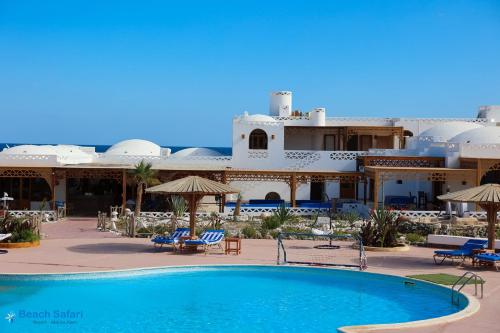 马萨阿拉姆Beach safari nubian resort的一座带游泳池的度假村,位于一座建筑前
