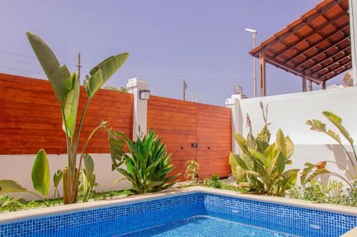 普拉亚Villa PalMarina的一座游泳池,位于带植物的围栏前