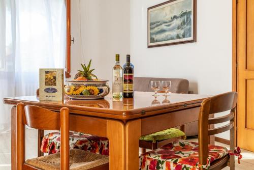 里米尼查尔斯公寓酒店的一张带两把椅子的木桌和葡萄酒瓶