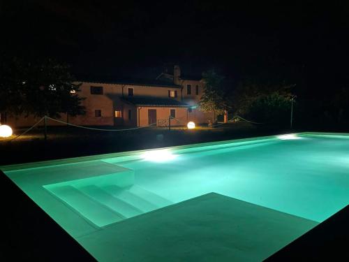 斯佩洛Podere Le Volte degli Angeli的游泳池在晚上点亮