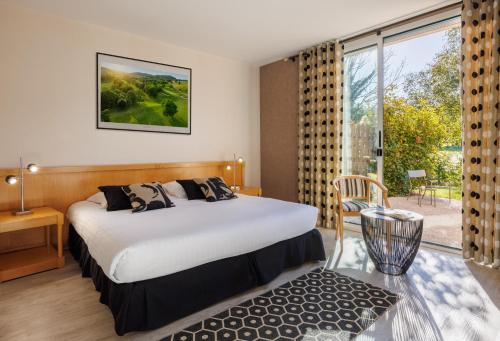 韦尔南图瓦Golf Domaine Du Val De Sorne的酒店客房设有一张床和一个大窗户