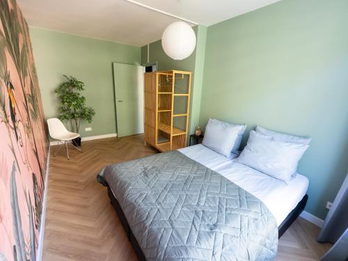 鹿特丹Rotterdam's coolest apartment的一间卧室设有一张床和绿色的墙壁