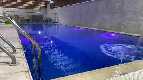 杰里科alzain villas - فلل الزين اريحا的蓝色水和紫色灯的游泳池