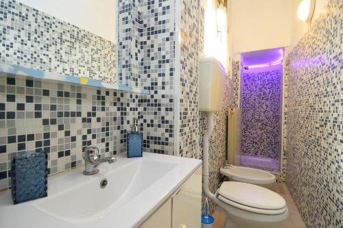 比耶拉il sogno的一间带卫生间、水槽和紫色门的浴室