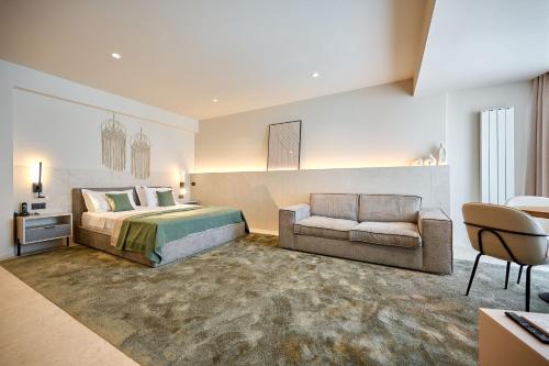 北马马亚-讷沃达里Alezzi Infinity Aparthotel & Spa的一间大卧室,配有一张床和一张沙发