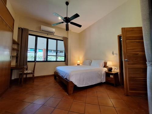 讪柿Chalala Tropical Garden House的一间卧室配有一张床和吊扇