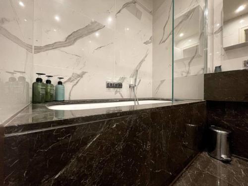 齐格威尔2BR Urban Vista Retreat CHCL F7的一间带浴缸和玻璃淋浴的浴室