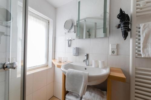 NiedersalweyFerienhaus Panoramablick的白色的浴室设有水槽和窗户。