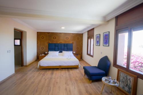 AÃ¯n el KsobVilla Tizra - guest house的一间卧室配有一张大床和蓝色床头板