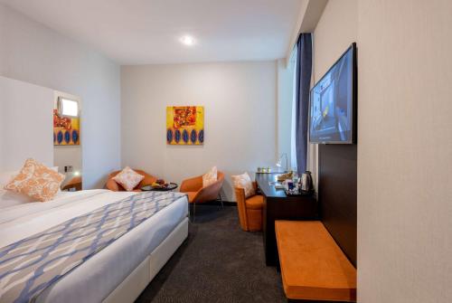 多哈Ramada Encore Doha by Wyndham的配有一张床和一台平面电视的酒店客房