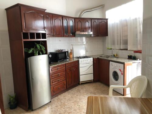 塔拉法尔Tarrafal Ecodécor Full House的厨房配有木制橱柜和不锈钢冰箱。